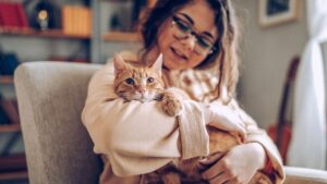 Young girl holding a yellow tabby cat